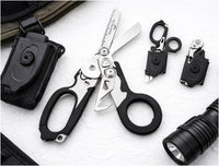 Black-handled trauma shears beside a holster, pouch and flashlight